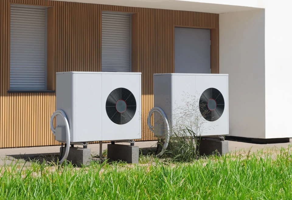 Ext&eacute;rieur r&eacute;sidentiel moderne avec pompe &agrave; chaleur air-eau install&eacute;e sur terrasse b&eacute;ton