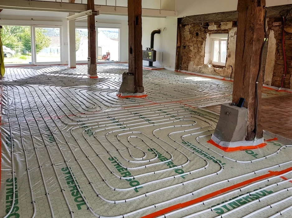 Intérieur en rénovation, grande pièce avec colonnes en bois apparentes et murs en pierre