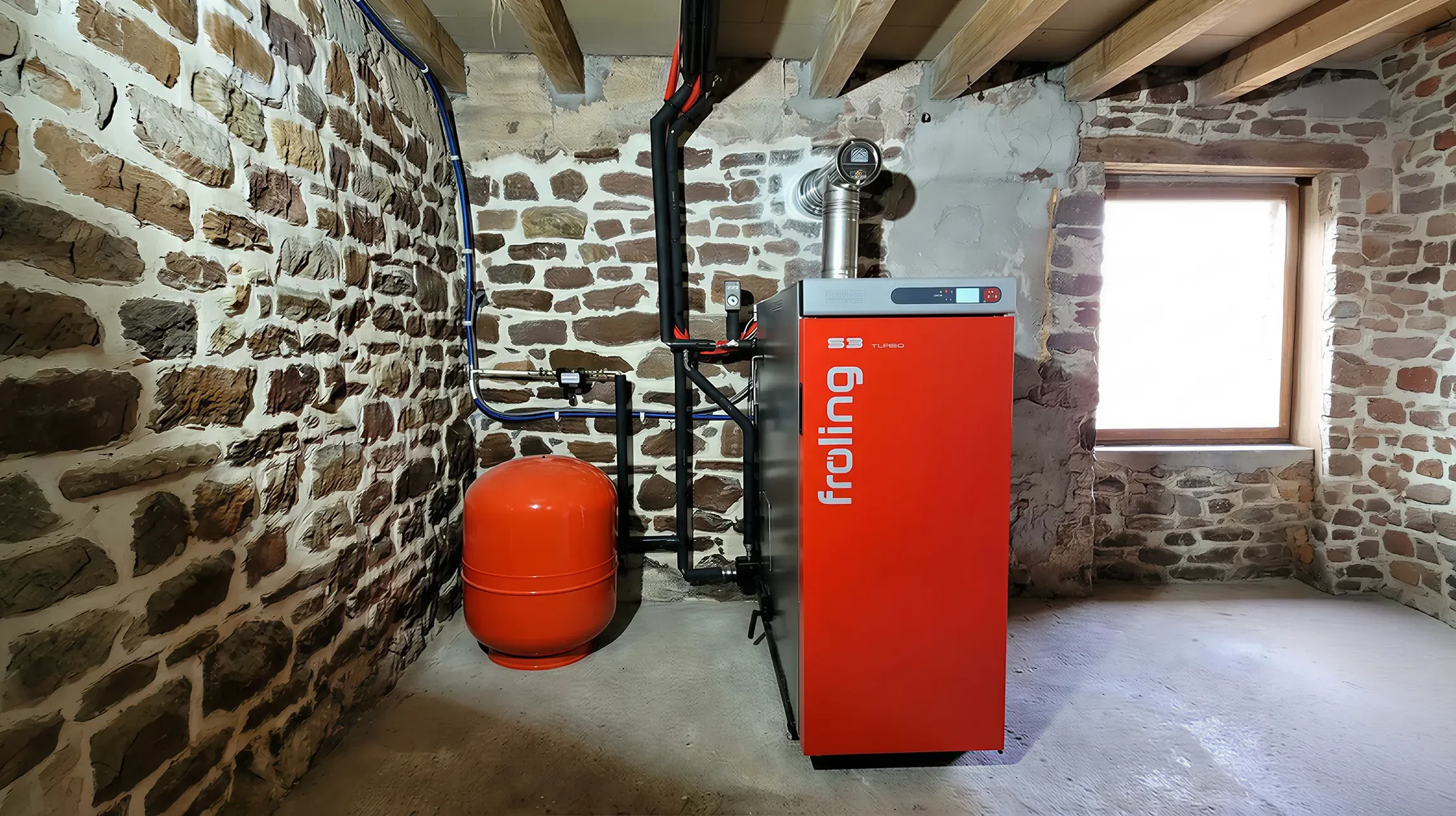Un homme travaille sur un syst&egrave;me de chauffage sous-pente dans un espace r&eacute;duit, manipulant des connexions hydrauliques avec un outil sp&eacute;cialis&eacute;